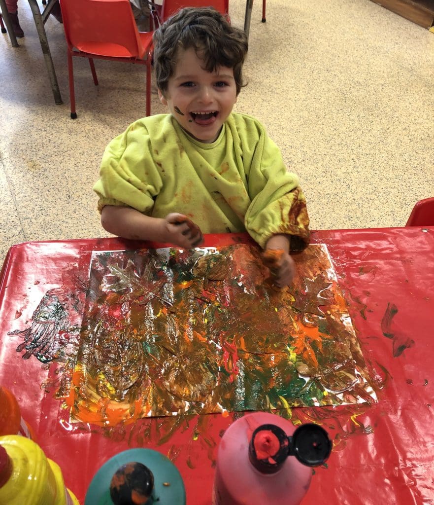 enfant avec le syndrome d'angelman fait de la peinture